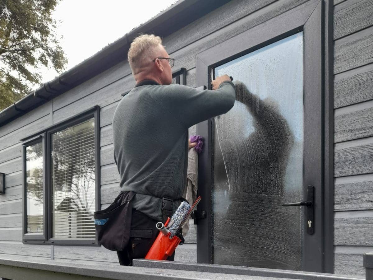 Traditional window cleaner cleaning windows at a property
